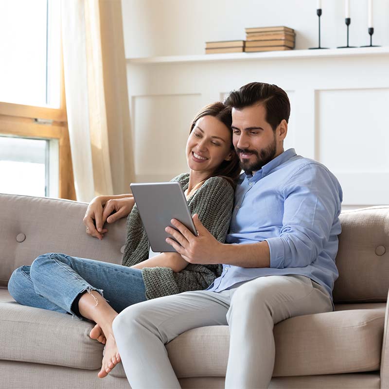 Happy couple looking on the tablet how to sell the house fast, 3-Step Home Buyer